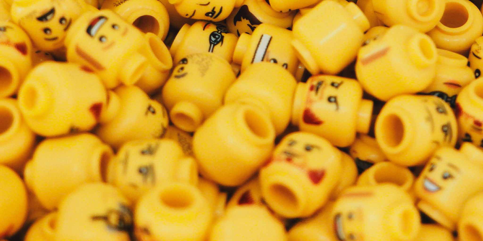 Closeup on a variety of yellow Lego minifigure heads