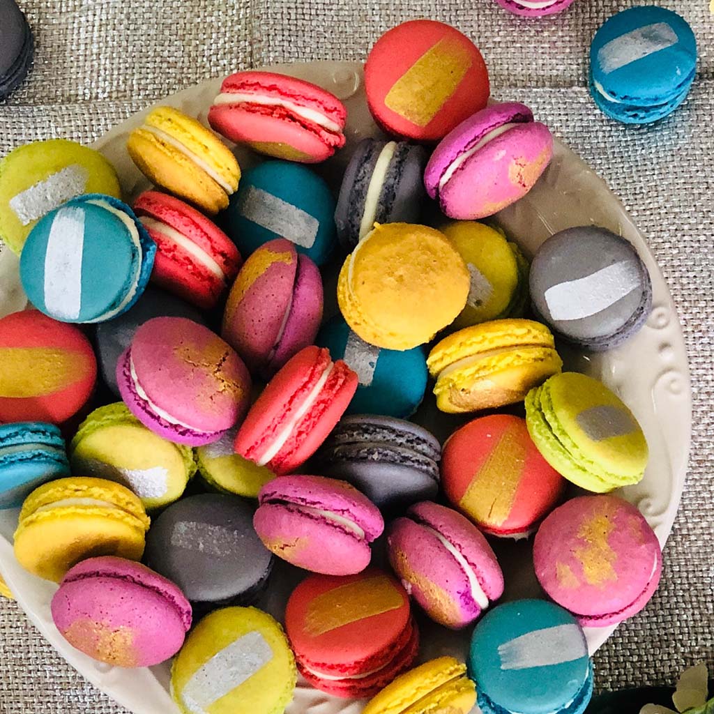 Closeup of a bowl full of colourful macaron cookies.